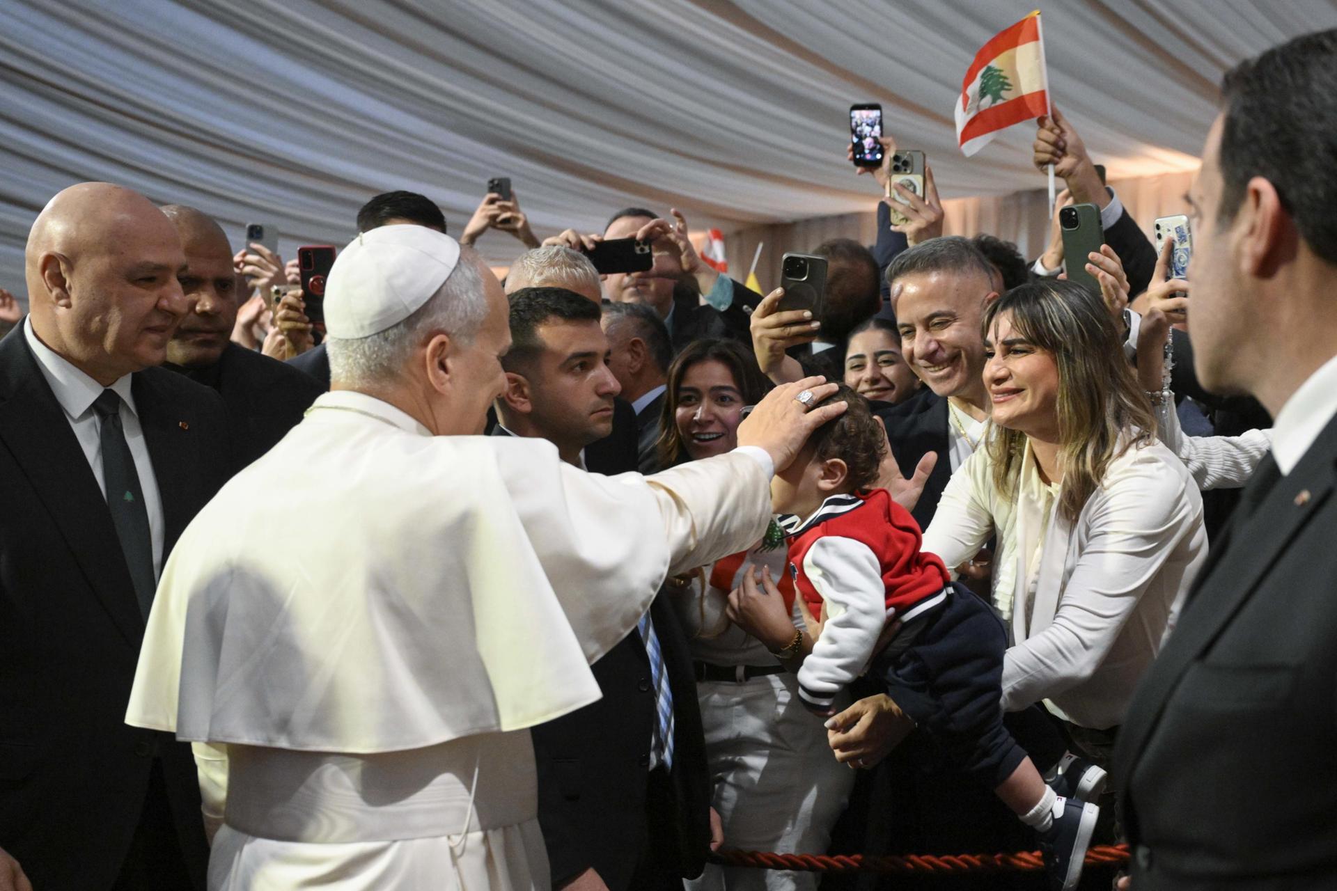 Beirut (Lebanon), 30/11/2025.- A handout picture made available by Vatican Media shows Pope Leo XIV (C) blessing a child while Lebanon President Joseph Aoun (L) looks on during the Pope's arrival at Beirut International Airport, Beirut, Lebanon, 30 November 2025. Pope Leo XIV is on his first apostolic visit outside Italy since his election as pontiff. He visited Turkey from 27 November and continues his journey to Lebanon from 30 November until 02 December. (Papa, Italia, Líbano, Turquía) EFE/EPA/VATICAN MEDIA HANDOUT HANDOUT EDITORIAL USE ONLY/NO SALES