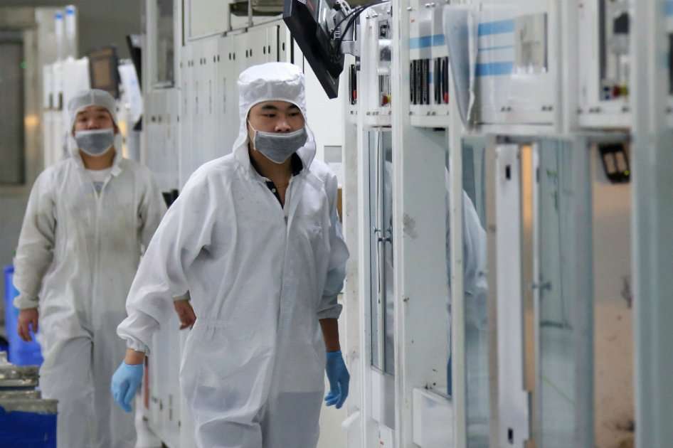 Empleados en la línea de producción de células solares en la fábrica de Trina Solar Ltd. en Changzhou, provincia de Jiangsu, China. / Bloomberg News