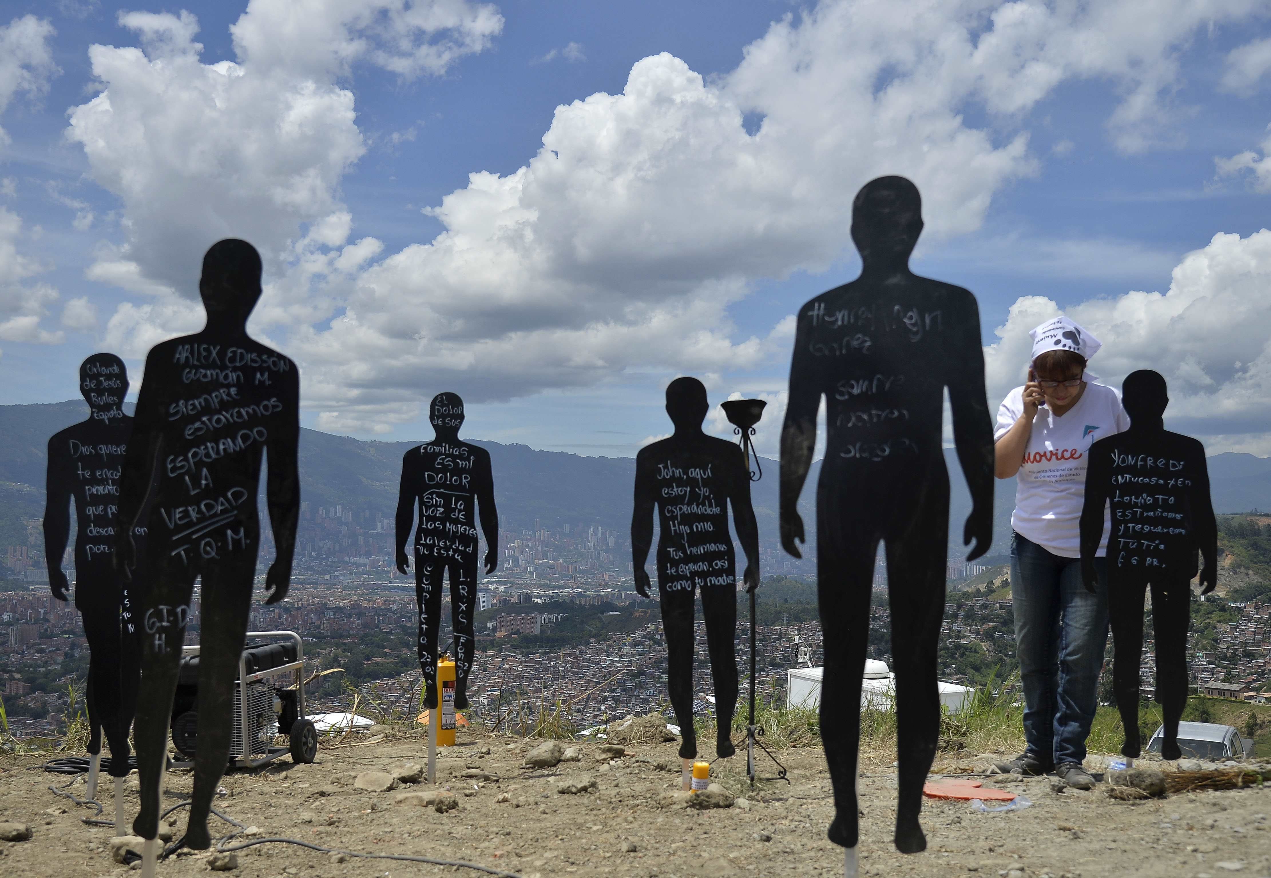 Relatives of missing people participate in a ceremony at "La Escombrera" rubbish dump in the 13 Commune shantytown in Medellin, Antioquia department, Colombia on July 27, 2015. In 2002, Medellin was rocked by violence after the government's decision to recover part of the city disputhttp://emvd-sypho-01/Symphonia_5/images/btnSaveNew.gifed by right-wing paramilitaries and militias, during which dozens of people were killed, more than 100 people were injured, 100 went missing and 200 families were displaced. During five months, Colombian prosecutors will begin the search for the bodies disappeared during the war conflicts in the area, where one of the largest mass graves is believed to be, the government said. AFP PHOTO / RAUL ARBOLEDA
