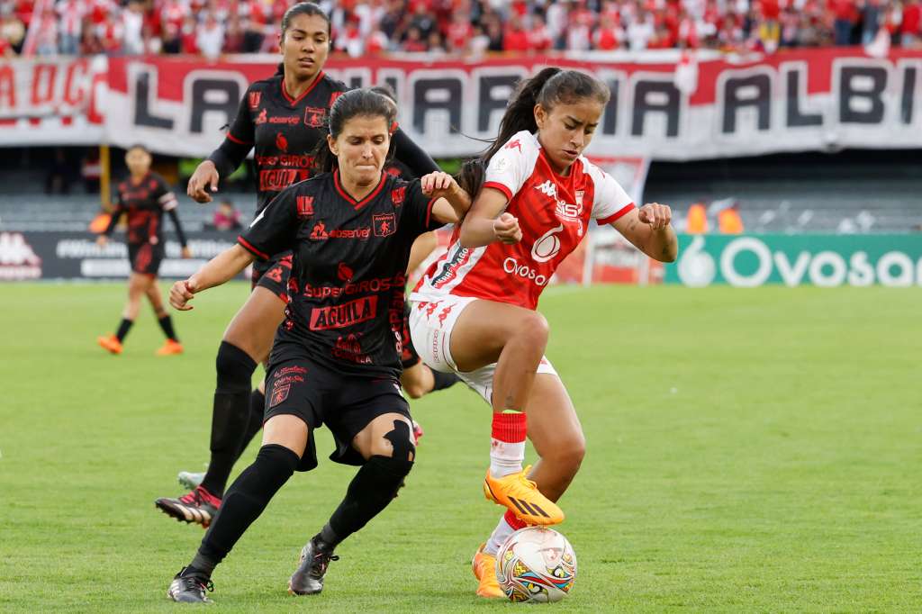 AMDEP4953. BOGOTÁ (COLOMBIA), 25/06/2023.- Karla Viancha (d) de Santa Fe disputan el balón con Mildrey Pineda de América hoy, en el juego de ida de la final de la Liga Femenina del fútbol profesional colombiano entre Santa Fe y América en el estadio El Campín en Bogotá (Colombia). EFE/ Mauricio Dueñas Castañeda