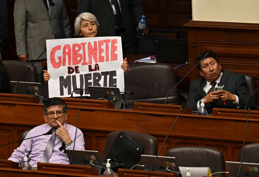 AME5315. LIMA (PERÚ), 10/01/2023.- Una mujer miembro del Congreso sostiene una pancarta mientras escuha al primer ministro de Perú, Alberto Otarola, mientras él y su gabinete enfrentan un voto de confianza, hoy, en Lima (Perú). El primer ministro de Perú, Alberto Otárola, quien encabeza el segundo gabinete del Gobierno de Dina Boluarte, llegó este martes al Congreso para pedir el voto de confianza del Parlamento, un proceso obligatorio que deben pasar tras el nombramiento, en medio de la escalada de violencia en el sur del país por protestas antigubernamentales que el lunes dejaron un saldo de 17 fallecidos. EFE/ Cris Bouroncle / Pool