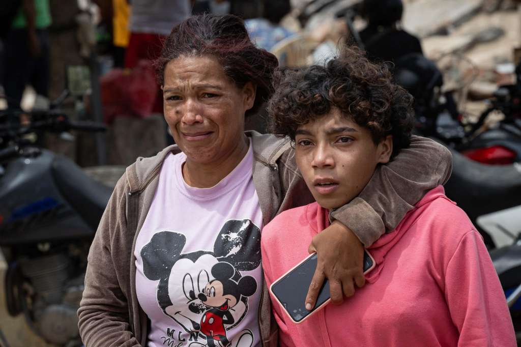 AME4360. LA GUAIRA (VENEZUELA), 25/06/2026.- Personas lloran al observar escombros de edificios derrumbados por terremotos este jueves, en La Guaira (Venezuela). El número de fallecidos en Venezuela a causa de los dos terremotos del miércoles se elevó a 188 y el de heridos a 1.520, mientras que al menos 346 construcciones, entre edificios, hospitales y centros comerciales, resultaron afectadas, informó el presidente de la Asamblea Nacional (AN, Parlamento), el chavista Jorge Rodríguez. EFE/ Ronald Peña R.
