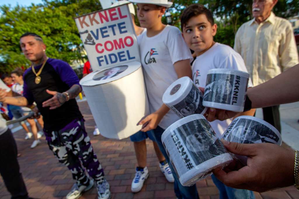 Miami (United States), 01/07/2022.- Cuban Singer Osmani Garcia 'La Voz' (L), stands next to a paperboard-made toilet with the image of the Cuban President Miguel Diaz Canel, which says in Spanish 'Kknel, go away like Fidel', during the shooting of the video of his new song 'KKNEL' at the Calle 8 street in Miami, Florida, USA, 01 July 2022. Attendees brought banners with the face of the Cuban President Diaz Canel as Hitler, calling him a fascist. 11 July is the first anniversary of the demonstrations by the Cuban people in Cuba against the government. (Protestas, Estados Unidos) EFE/EPA/CRISTOBAL HERRERA-ULASHKEVICH