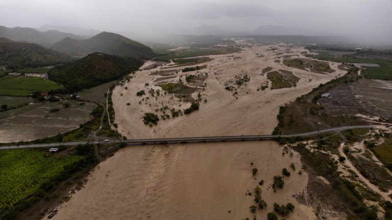 -FOTODELDÍA- PALMAR DE OCOA (REPÚBLICA DOMINICANA), 04/10/2023.- Fotografía aérea que muestra el Río Ocoa completamente desbordado y con un intenso caudal producto de la fuertes lluvias, hoy en Palmar de Ocoa (República Dominicana). Una persona está desaparecida, al menos 1.522 fueron desplazadas de sus hogares y un puente colapsó debido a las intensas lluvias en la República Dominicana, que han llevado a las autoridades a decretar la alerta en 30 de las 32 provincias del país, 11 en nivel rojo. EFE/Orlando Barría