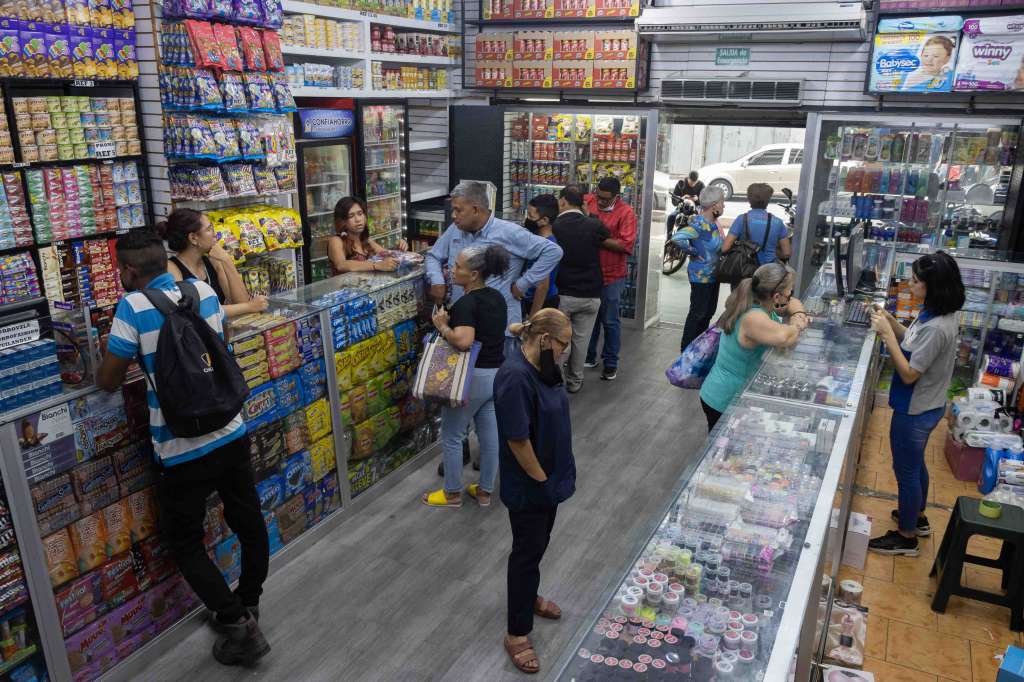 AME9794. CARACAS (VENEZUELA), 16/05/2022.- Personas acuden a comprar a una tienda, el 11 de mayo de 2022, en Caracas (Venezuela). Venezuela, en plena recuperación económica tras siete años de caída, prevé para este año un crecimiento de entre el 5 y el 8 Venezuela, en plena recuperación económica tras siete años de caída, prevé para este año un crecimiento de entre el 5 y el 8 %, según expertos, que consideran que la mejora será irregular en los diferentes sectores y difícil de mantener en el tiempo. La actividad económica, que se contrajo un 80 % desde 2013, responde positivamente a un cambio en las políticas del Gobierno, que se ha abierto al dólar, tras años de rechazo a la divisa, y a inversionistas privados, a la vez que redujo los controles y las intervenciones a empresas, según explicó a Efe el economista Giorgio Cunto. EFE/ Ronald Peña