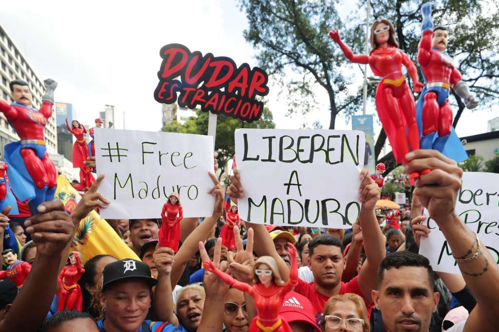 AME2125. CARACAS (VENEZUELA), 04/01/2026.- Personas sostienen carteles y figuras del presidente de Venezuela, Nicolás Maduro, y de su esposa, Cilia Flores, durante una marcha del chavismo este domingo, en Caracas (Venezuela). El chavismo convocó a sus simpatizantes a una "gran marcha" por la libertad de Maduro, y de su esposa quienes fueron capturados la madrugada del sábado por fuerzas estadounidenses en Caracas, como parte de una operación que incluyó ataques en la capital y tres estados cercanos. EFE/ Ronald Peña R