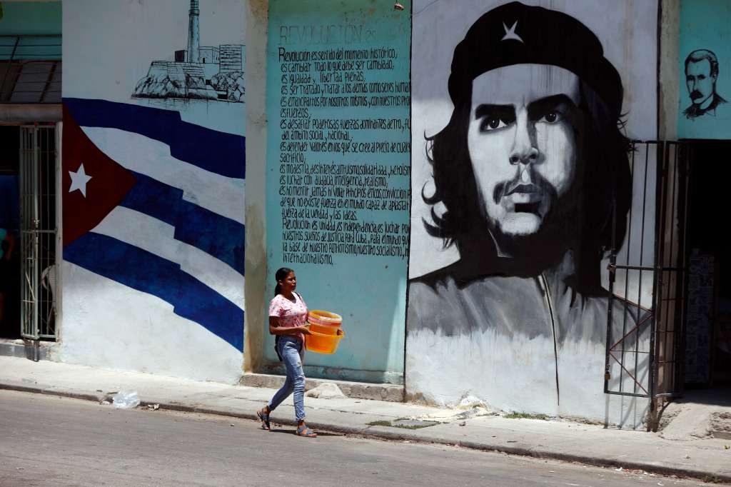 AME655. LA HABANA (CUBA), 26/04/2024.- Una mujer camina frente a un mural con la imagen de Ernesto Ché Guevara este viernes en una calle de La Habana (Cuba). EFE/ Ernesto Mastrascusa