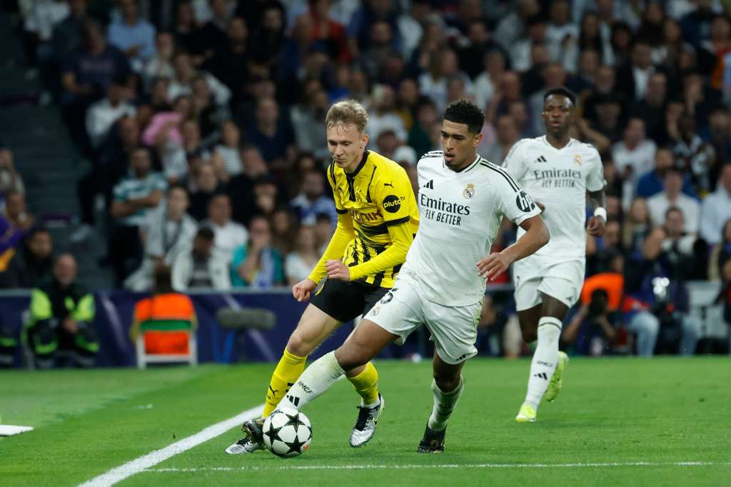 MADRID, 22/10/2024.- El centrocampista inglés del Real Madrid, Jude Bellingham, se lleva el balón ante el jugador del Borussia durante el encuentro correspondiente a la fase regular de la Liga de Campeones entre Real Madrid y Borussia Dortmund, este martes en el estadio Santiago Bernabéu, en Madrid. EFE/Juanjo Martín.