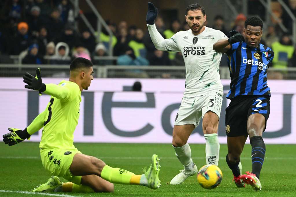 Denzel Dumfries, carrilero del Inter de Milán, intenta un remate ante la salida de Devis Vásquez, portero colombiano del Empoli.