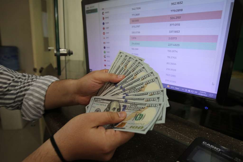 Peshawar (Pakistan), 15/08/2023.- A foreign currency dealer sorts US Dollars at a money exchange company in Peshawar, Pakistan, 15 August 2023. The US dollar on 15 August reached Rs300 mark in open market during intraday trading against Pakistani rupee days after the National Assembly was dissolved, handing over the powers to the caretaker Prime Minister Anwaarul Haq Kakar. The intraday trading, the greenback gained Rs4 to reach the Rs300 against the local currency, which also lost ground in the interbank market. (Abierto) EFE/EPA/ARSHAD ARBAB
