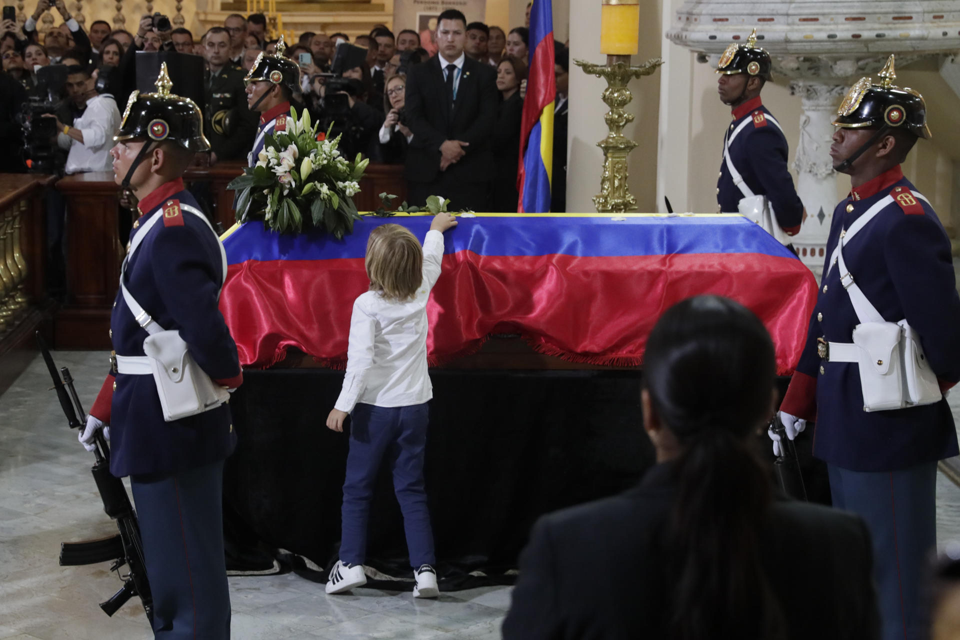 AME9840. BOGOTÁ (COLOMBIA), 13/08/2025.- El hijo del fallecido senador y precandidato presidencial Miguel Uribe Turbay, Alejandro, deja una flor sobre su féretro en una misa este miércoles, en la catedral Primada en Bogotá (Colombia) Uribe Turbay falleció el lunes, dos meses después de un atentado en su contra. EFE/Carlos Ortega
