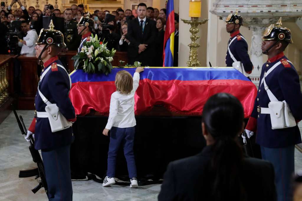 AME9840. BOGOTÁ (COLOMBIA), 13/08/2025.- El hijo del fallecido senador y precandidato presidencial Miguel Uribe Turbay, Alejandro, deja una flor sobre su féretro en una misa este miércoles, en la catedral Primada en Bogotá (Colombia) Uribe Turbay falleció el lunes, dos meses después de un atentado en su contra. EFE/Carlos Ortega