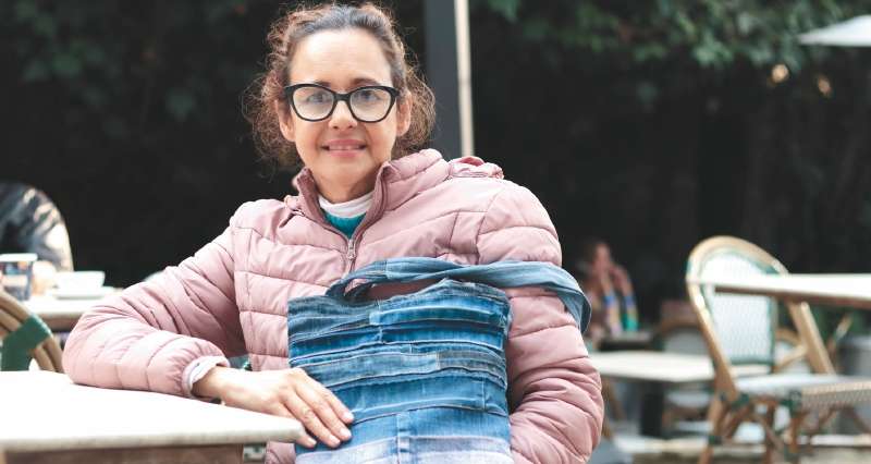 Carmen Peñuela, en la feria dentro del restaurante Harry Sasson, con una cartera que ella misma elaboró a partir de retazos de jean.
