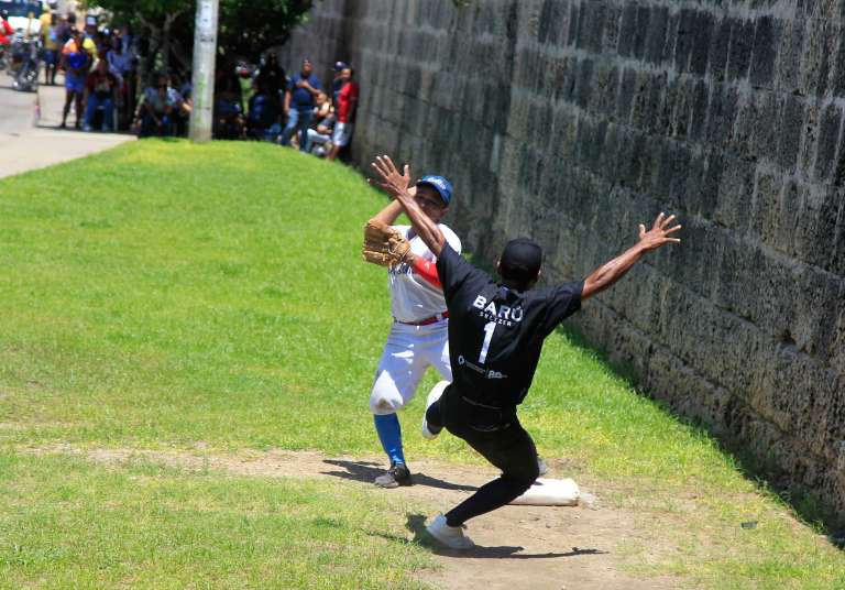 AME1762. CARTAGENA (COLOMBIA), 02/10/2022.- Habitantes del histórico barrio de Getsemaní juegan la final del campeonato de Bola de Trapo, un tradicional juego similar al beisbol que se juega con una bola elaborada con trapos e hilo forrados con un cuero semejando la original pelota caliente, en Cartagena (Colombia). Esta es una tradición que los getsemanicenses tratan de mantener viva a pesar de no contar con ninguna clase de apoyo por parte de las autoridades municipales de la ciudad, y es también una forma de resistencia frente a la fuerte gentrificación que sufre este sector de la ciudad invadido por el turismo. EFE/ Ricardo Maldonado Rozo