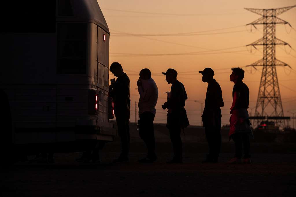 Yuma (United States), 12/05/2023.- Migrants board a bus that will take them to a processing center after crossing from Mexico to the United States, in Yuma, Arizona, USA, 11 May 2023. A significant increase in the number of migrants crossing is expected as the Covid-era Title 42 policy, which allowed for a quick expulsion of illegal immigrants, is set to expire 11 May. (Estados Unidos) EFE/EPA/ETIENNE LAURENT