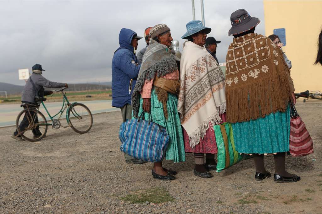 AME9620. LAJA (BOLIVIA), 19/10/2025.- Mujeres llegan a un centro votación este domingo, en la comunidad de Laja (Bolivia). Los pobladores de Laja en el altiplano de Bolivia, a 3.800 metros sobre el nivel del mar, acudieron a los colegios electorales cubiertos con frazadas desde temprano y bajo un cielo nublado para votar en la inédita segunda presidencial del país con la esperanza de que la crisis económica termine con el próximo gobierno. EFE/ Luis Gandarillas
