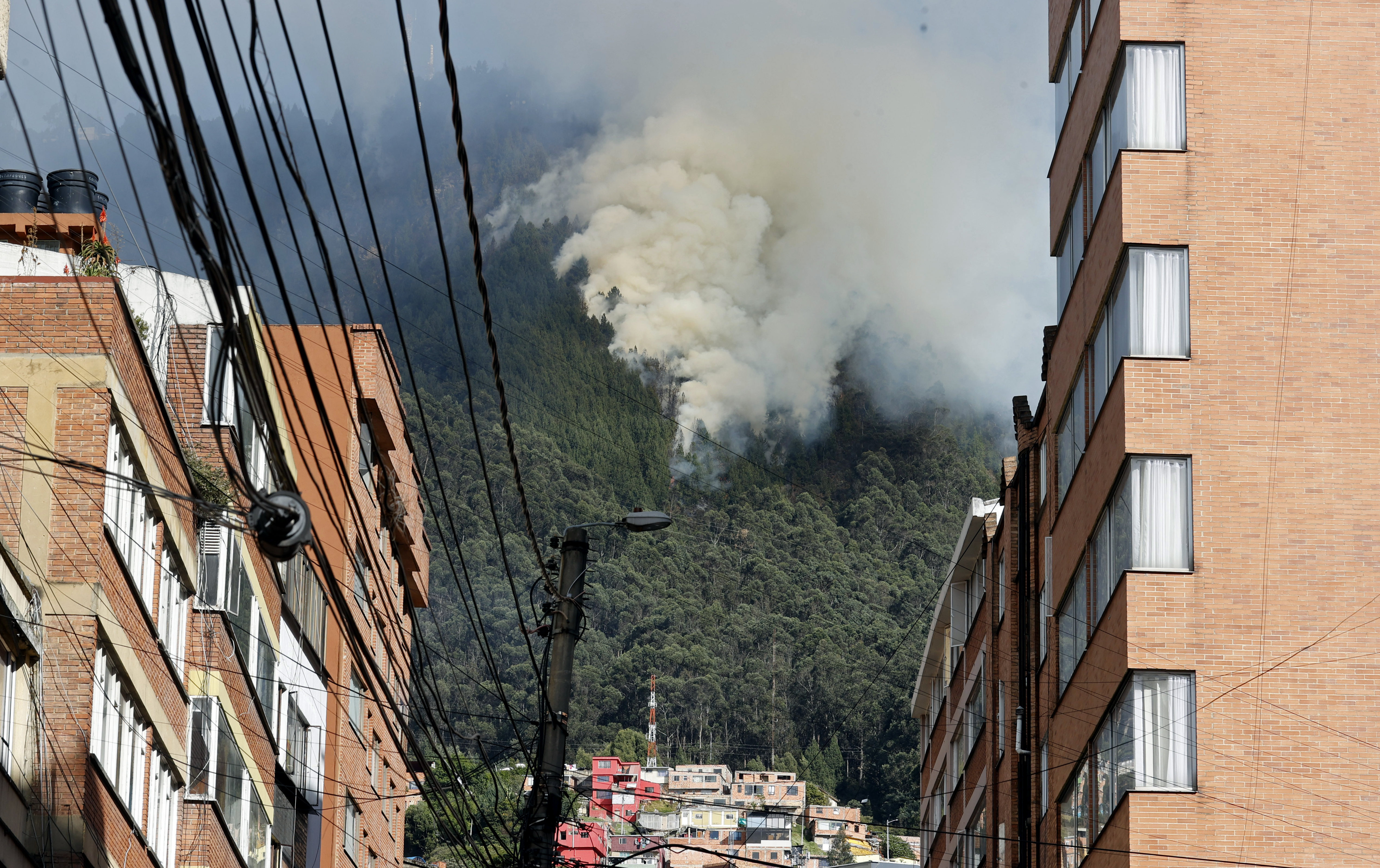 AME2080. BOGOTÁ (COLOMBIA), 24/01/2024.- Una gran columna de humo se eleva sobre la montaña debido a un incendio forestal en un sector de los cerros orientales hoy, en Bogotá (Colombia). El fenómeno de El Niño venía acechando a Colombia desde hace meses pero dio a conocer su cara más cruenta en los últimos días con numerosos incendios forestales que intimidan a las principales ciudades del país y arrasan hectáreas de los más emblemáticos paisajes colombianos. En este momento hay activos al menos cuatro incendios en Bogotá, según el alcalde Carlos Fernando Galán. EFE/ Mauricio Dueñas Castañeda