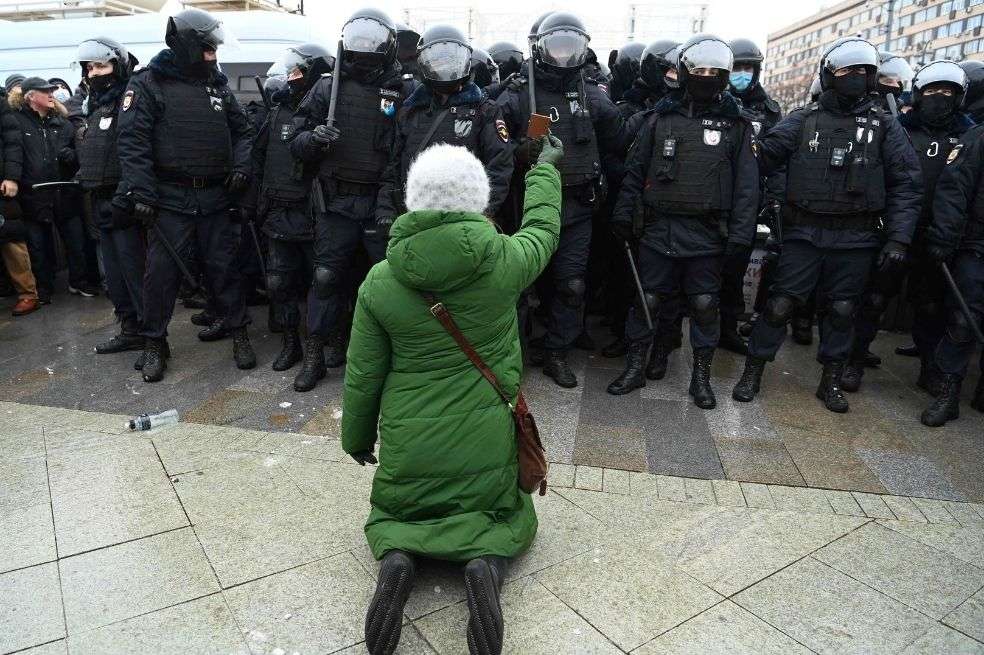 Una mujer se arrodilla frente a un grupo de policías antidisturbios durante una manifestación en apoyo del líder opositor encarcelado Alexei Navalny en Moscú.