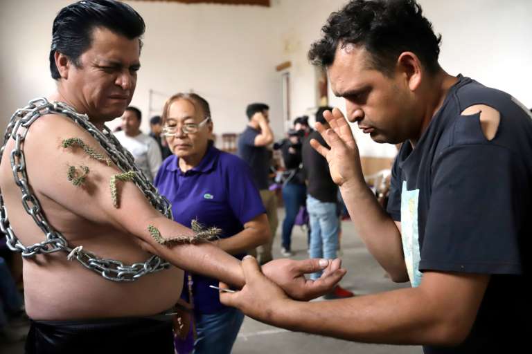MEX1551. ATLIXCO (MÉXICO), 07/04/2023.- Un hombre se prepara para participar en la procesión de los engrillados este Viernes Santo, durante las celebraciones de Semana Santa, en el municipio de Atlixco, en Puebla (México). Con fe y dolor, salieron este Viernes Santo a las calles los engrillados, mexicanos que se colocan cadenas y espinas en el cuerpo para peregrinar por el municipio de Atlixco, del estado de Puebla, centro del país. EFE/ Hilda Ríos