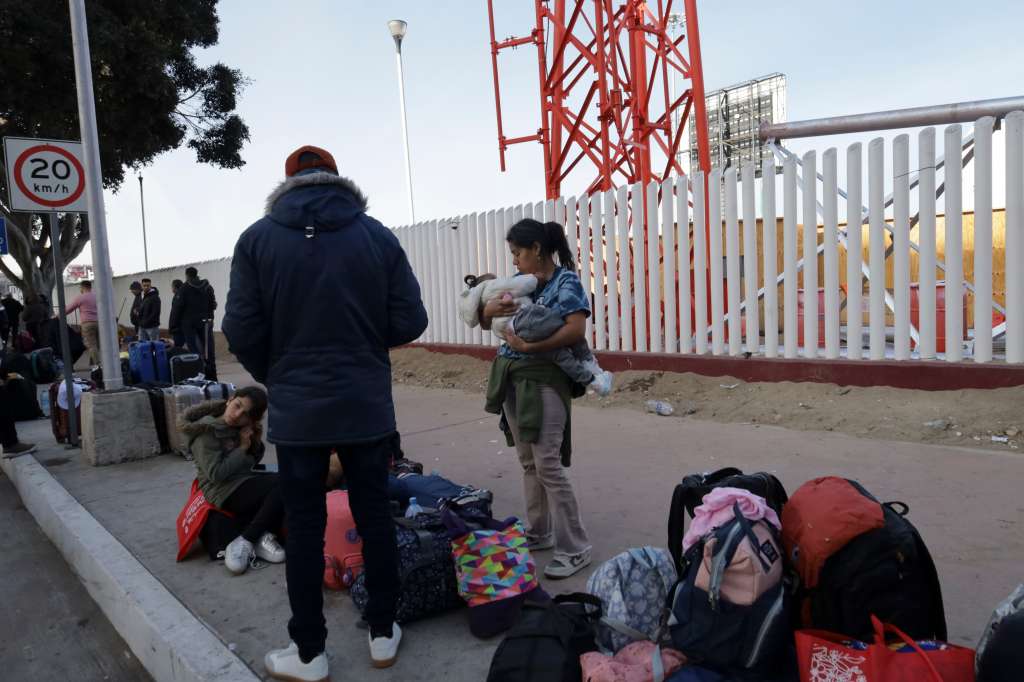 MEX333. TIJUANA (MÉXICO), 20/01/2025.- Migrantes permanecen varados este lunes, en el puerto fronterizo de El Chaparral, en Tijuana (México). Cientos de migrantes quedaron varados después de que el gobierno del nuevo presidente, Donald Trump, cancelara el programa CBP-One, que permitía a migrantes solicitar citas para pedir asilo en EE.UU. a través de los puertos de entrada en la frontera con México. EFE/ Joebeth Terríquez
