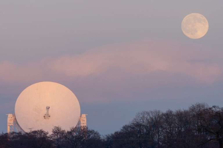 Esta foto de Matt Naylor muestra al Sol poniente iluminando las nubes, mientras la luna aparece sobre el telescopio Lovell, en Inglaterra.
