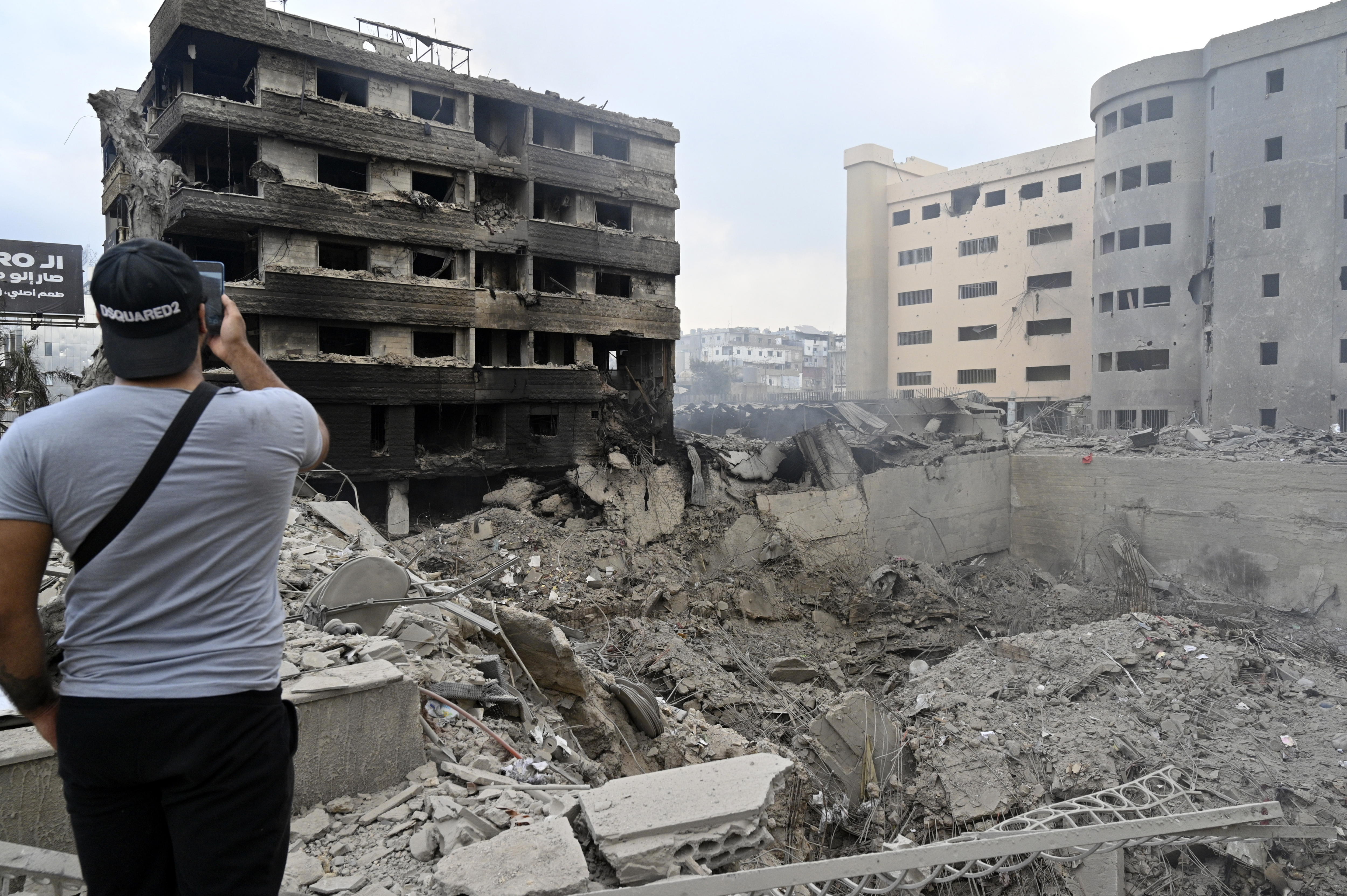 -FOTODELDIA- Beirut (Líbano), 07/10/2024.- Un hombre toma fotos de los daños causados tras un ataque aéreo israelí en la carretera del aeropuerto en el suburbio sur de Beirut, Líbano, 07 de octubre de 2024. Según el ministro de Sanidad libanés, más de 2.000 personas han muerto y más de 9.600 han resultado heridas en Líbano desde el comienzo del conflicto entre Israel y Hezbolá. EFE/WAEL HAMZEH
