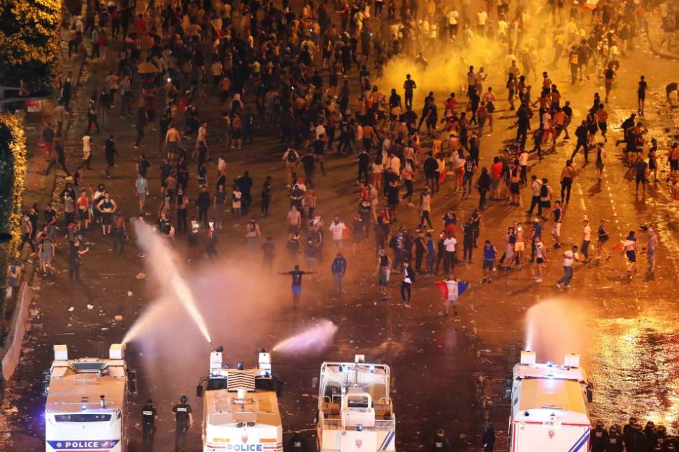 Agentes antidisturbios usan cañones de agua para dispersar a un grupo de alborotadores durante los disturbios ocurridos esta madrugada en la avenida de los Campos Elíseos en el marco de las celebraciones por la victoria de la selección francesa en el Mundial de Rusia. / EFE