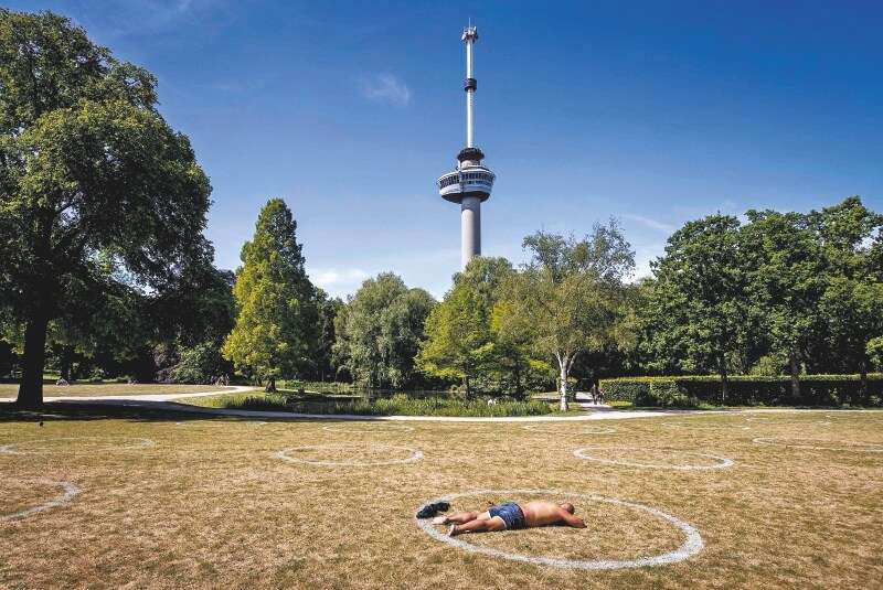 Un hombre toma el sol en un parque de Amsterdam. / AFP