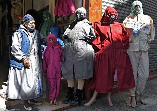 Una mujer boliviana vende en la paz tapabocas y material de protección contra el coronavirus.