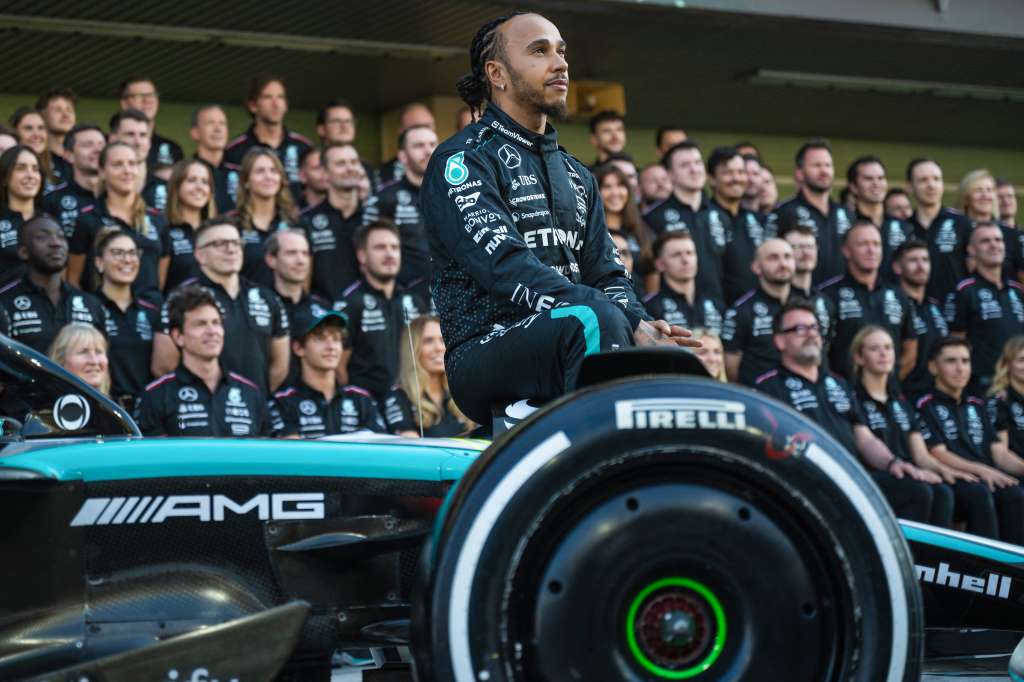 Mercedes' British driver Lewis Hamilton sits on his car as he poses for a group photo with his team ahead of the Abu Dhabi Formula One Grand Prix at the Yas Marina Circuit in Abu Dhabi on December 5, 2024. (Photo by Andrej ISAKOVIC / AFP)
