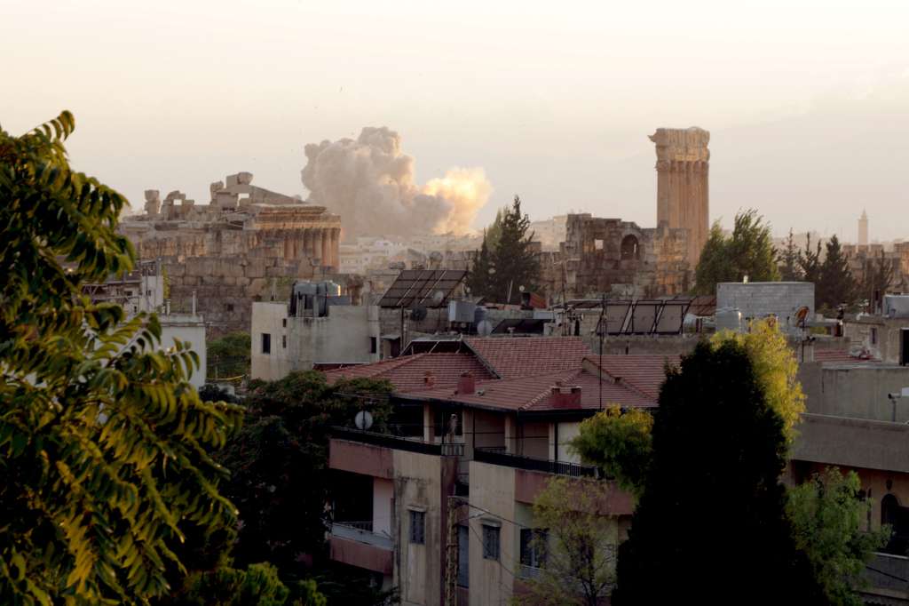 (FILES) Smoke billows from the site of an Israeli airstrike on the Lebanese city of Baalbeck in the Bekaa valley on September 23, 2024, behind the ancient Roman ruins and the six columns that remain standing at the Temple of Jupiter.