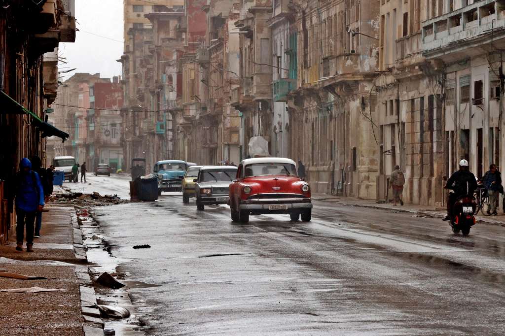AME519. LA HABANA (CUBA), 01/02/2026.- Fotografía de vehículos bajo la lluvia este domingo, en La Habana (Cuba). Inundaciones asociadas a un frente frío y fuertes marejadas para el litoral norte del occidente, con impacto probable en La Habana, se prevé un incremento de los vientos del noroeste y marejadas que podrían alcanzar intensidades fuertes en el litoral norte. EFE/ Ernesto Mastrascusa