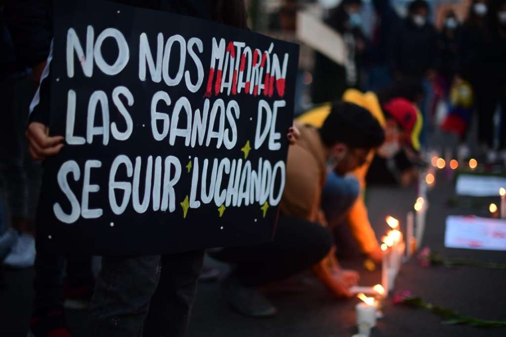 Una persona sostiene un letrero que dice no nos matarán las ganas de seguir luchando.