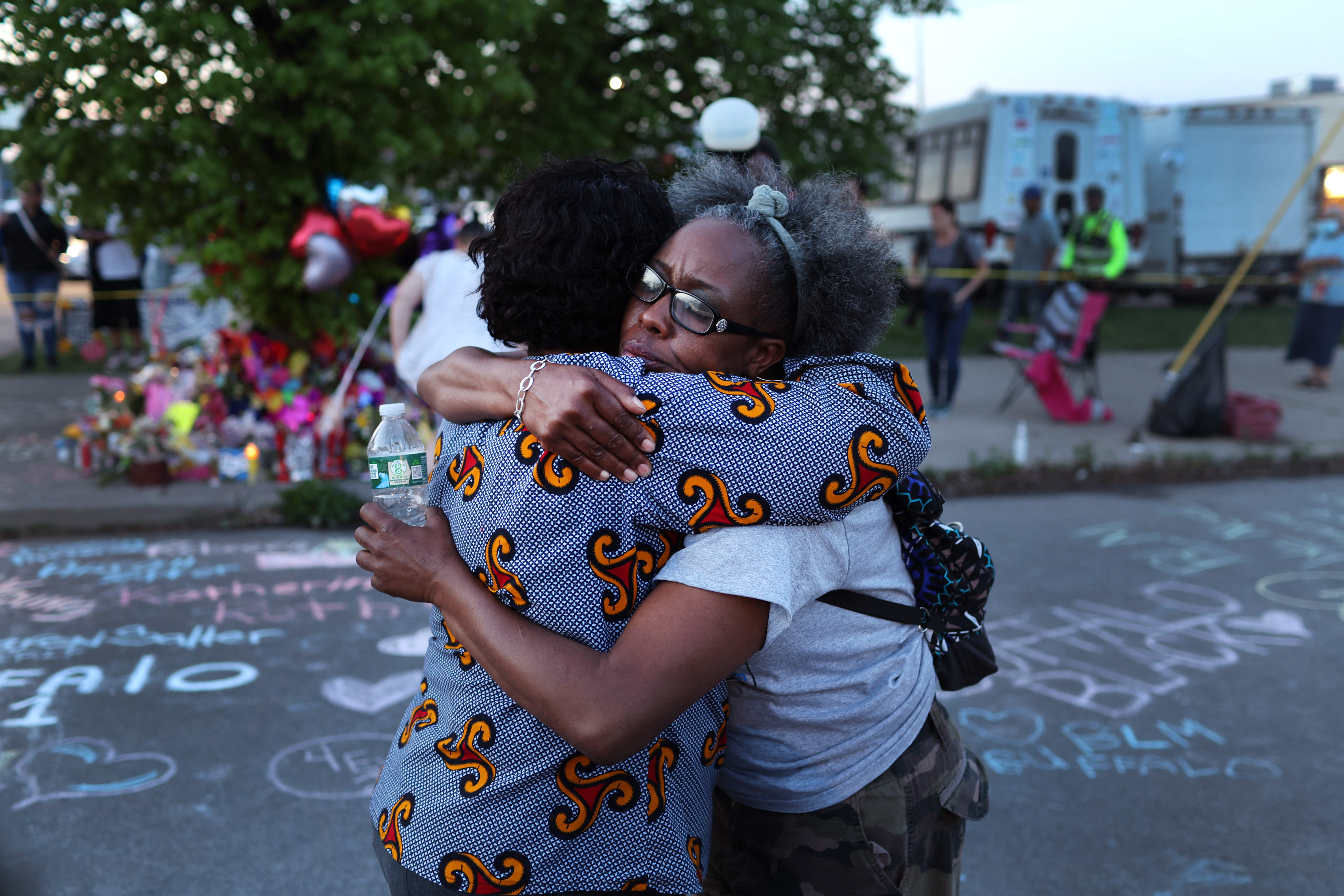 Familiares y allegados de las víctimas visitan un monumento improvisado fuera del mercado de Tops el 15 de mayo de 2022 en Buffalo, Nueva York.