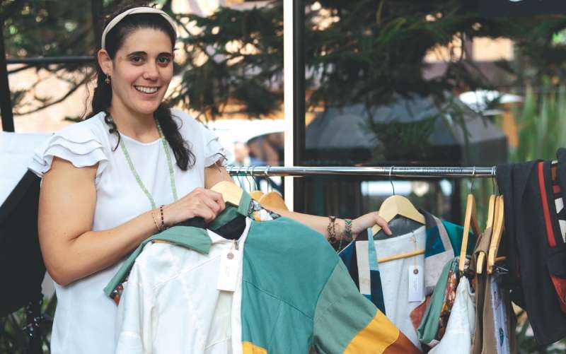 Ana Karina García, directora de la fundación Juntos se Puede, junto a las prendas elaboradas por mujeres de la organización.