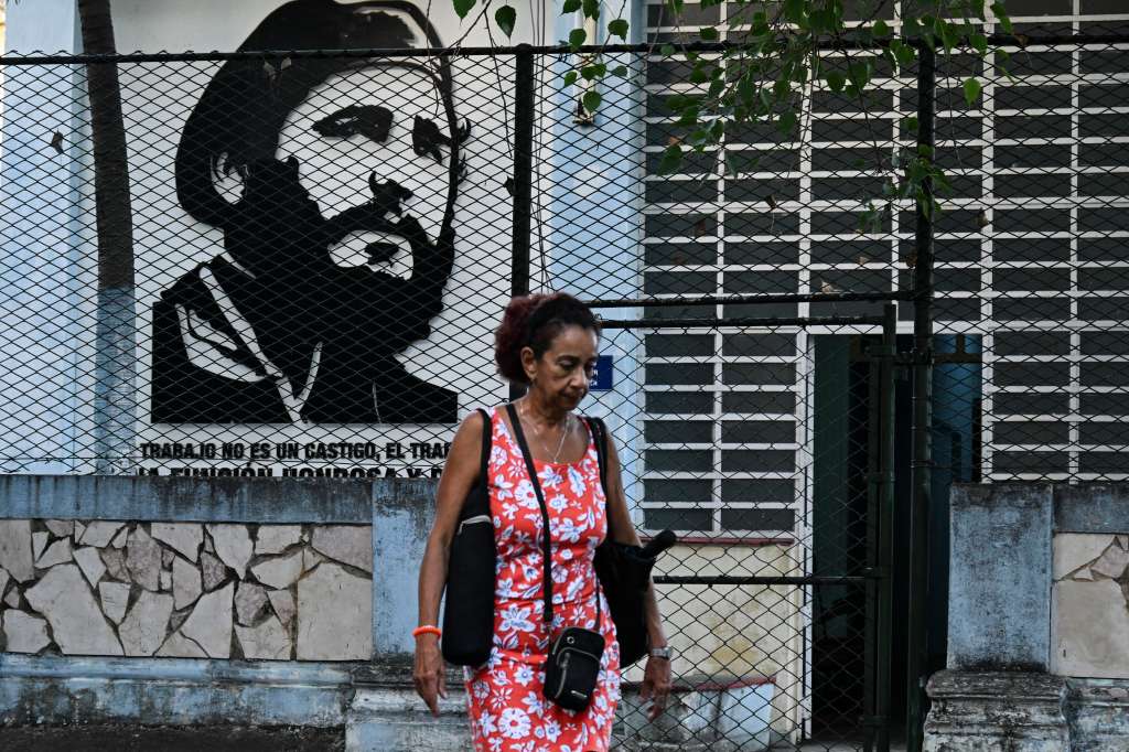 Una mujer pasa frente a un retrato de Fidel Castro en La Habana (Cuba).