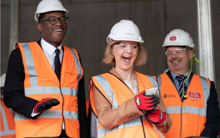 Liz Truss, y el ministro de Hacienda de Gran Bretaña, Kwasi Kwarteng, con cascos y chaquetas de alta visibilidad, visitan un sitio de construcción para un campus de innovación médica en Birmingham, centro de Inglaterra, el 4 de octubre de 2022.