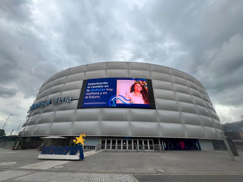 El Movistar Arena, brillando en tono azul, se erige como un símbolo de solidaridad y esperanza.