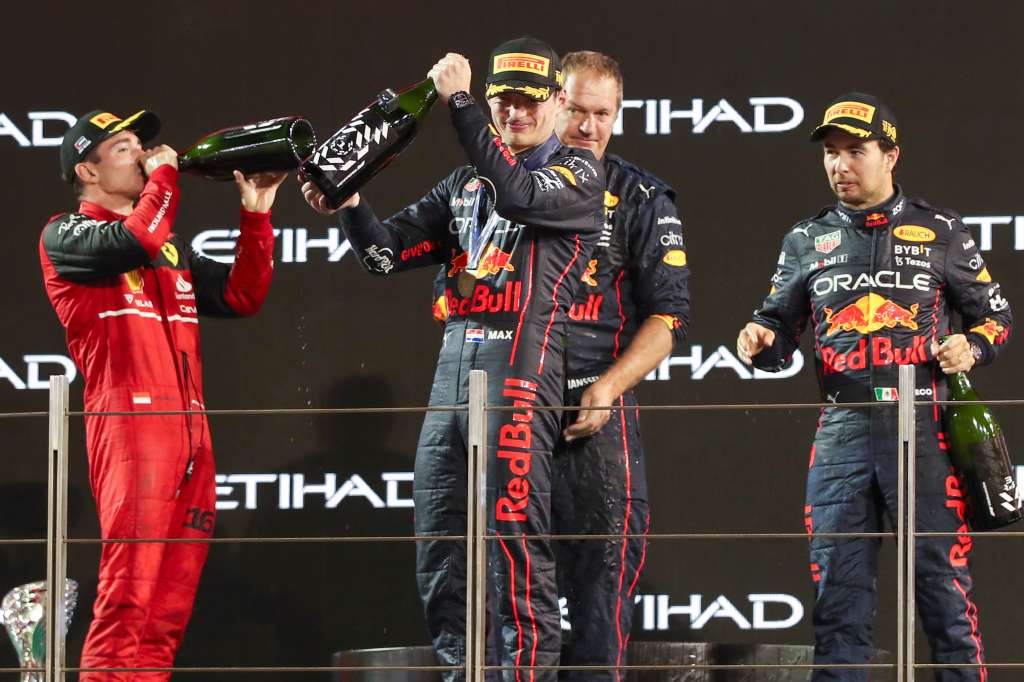 Abu Dhabi (United Arab Emirates), 20/11/2022.- Race winner Dutch Formula One driver Max Verstappen of Red Bull Racing (2-L), secon-placed Monaco's Formula One driver Charles Leclerc of Scuderia Ferrari (L), an unidentified team representative, and third-placed Mexican Formula One driver Sergio Perez of Red Bull Racing (R) smile on the podium following the Formula One Abu Dhabi Grand Prix at Yas Marina Circuit in Abu Dhabi, United Arab Emirates, 20 November 2022. (Fórmula Uno, Emiratos Árabes Unidos) EFE/EPA/ALI HAIDER