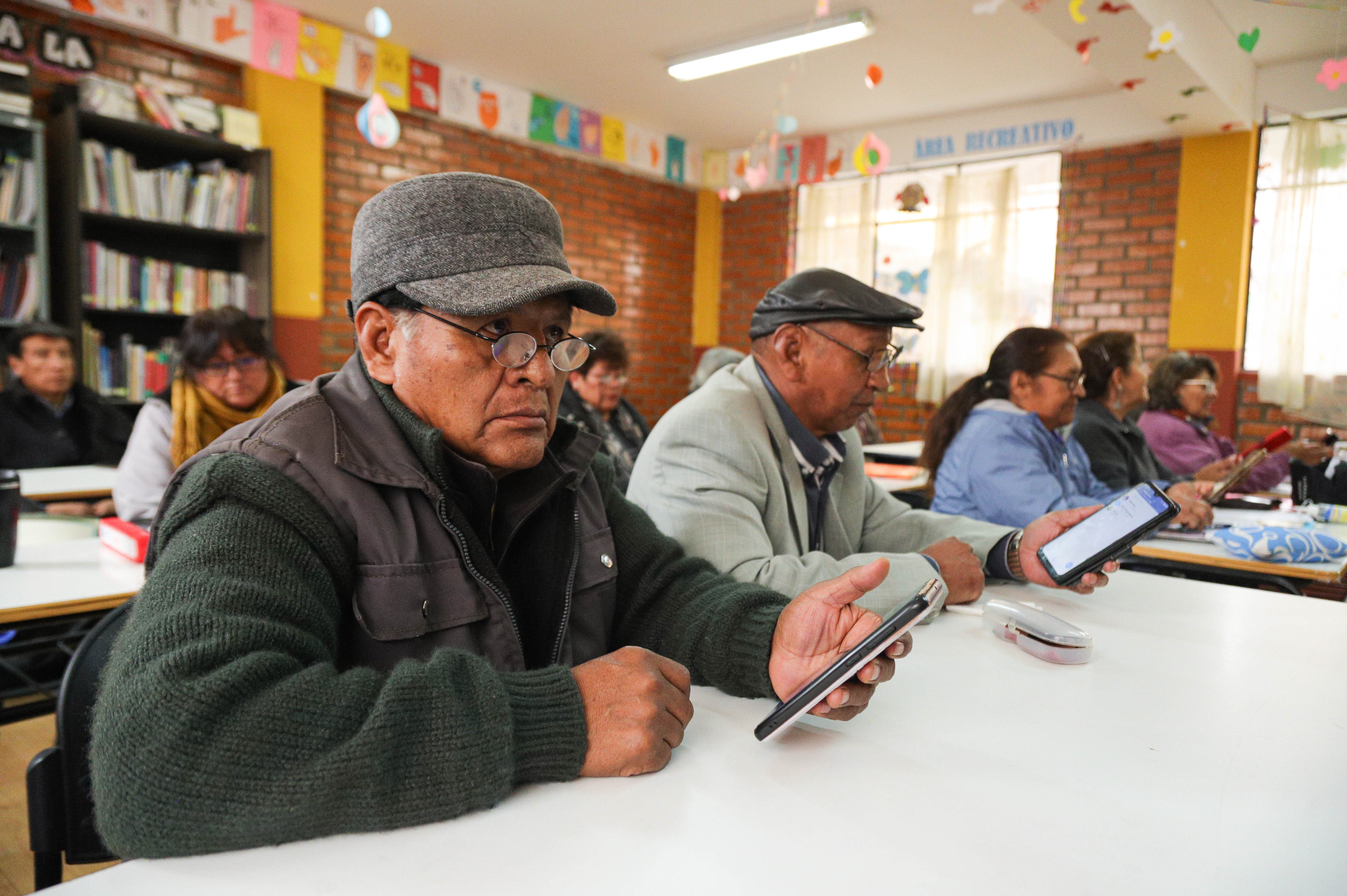 AME5525. LA PAZ (BOLIVIA), 08/10/2024.- Fotografía del 3 de octubre de 2024 de adultos mayores durante una clase de uso de teléfonos móviles en la universidad del Adulto Mayor en La Paz (Bolivia). Más de mil adultos mayores en Bolivia se capacitan en nuevas tecnologías, gastronomía y asesoramiento legal, entre otras áreas, para incorporarse en alguna actividad económica o que les permita tener una "vejez digna" e "independiente" en actividades cotidianas, en un país en donde 6 de cada 10 personas mayores de 65 años trabajan, la mayoría en la informalidad. EFE/ Gabriel Márquez