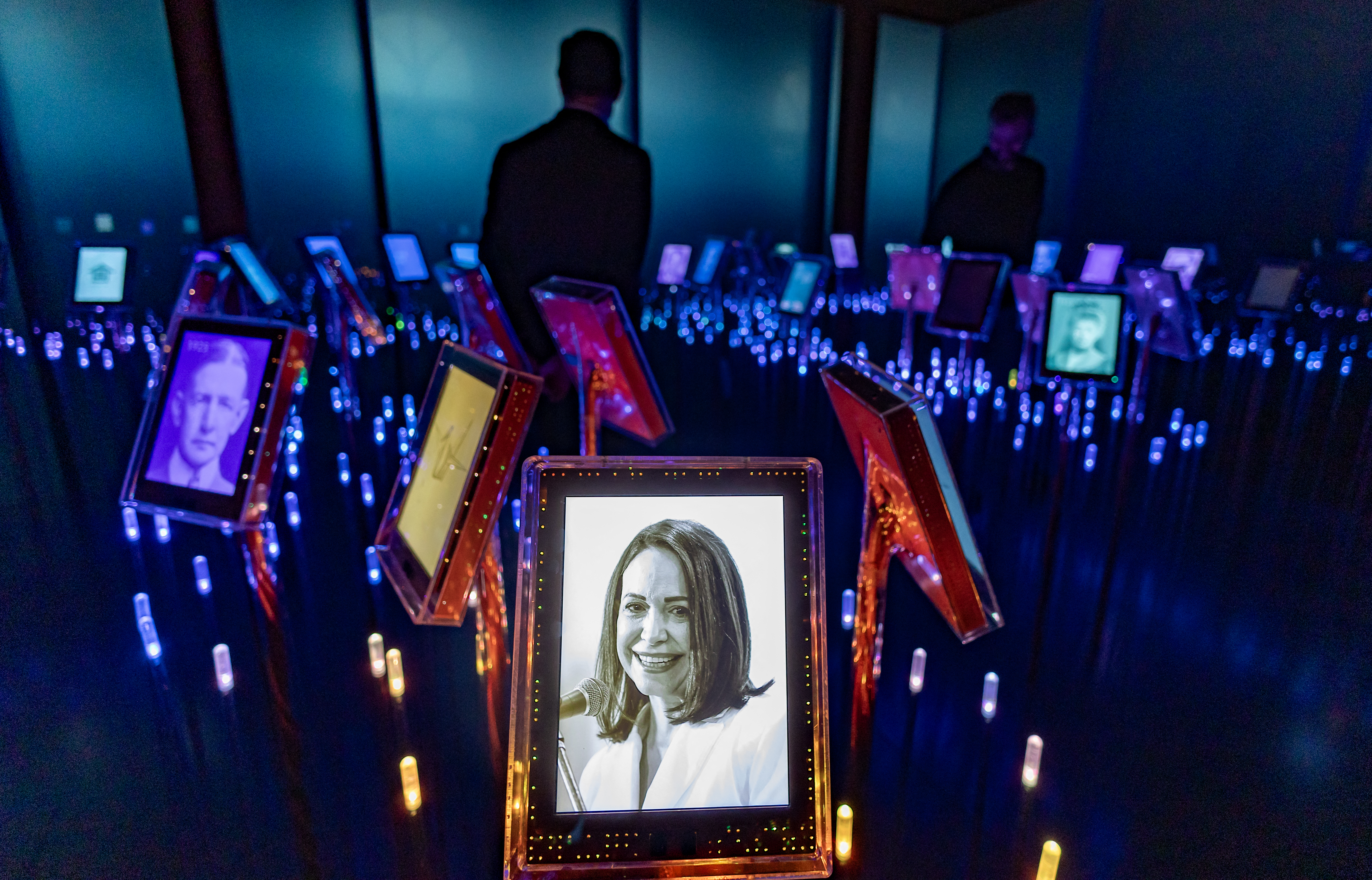 A picture of Nobel Peace Prize laureate Maria Corina Machado is seen among portraits of previous winners in the "Nobel Field" at the exhibition "Democracy on the brink" in honour of the laureate at the Nobel Peace Center in Oslo on December 9, 2025, on the eve of the Nobel Peace Prize ceremony. The new exhibition featuring the 2025 laureate opens to the public on December 12, 2024. (Photo by Odd ANDERSEN / AFP)