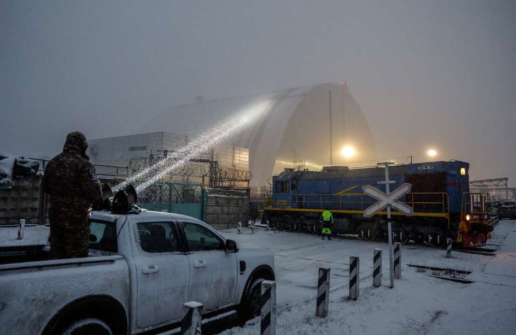 Chernobyl (Ukraine), 14/02/2025.- A Ukrainian serviceman directs a light towards a damaged protective shelter over the remains of the reactor Unit 4 at the Chernobyl nuclear power plant (NPP), near the city of Chernobyl, Ukraine, 14 February 2025, amid the Russian invasion. Ukraine's President Zelensky said on 14 February, that a Russian drone with a 'high-explosive warhead' struck the shelter covering the destroyed Unit 4 of the Chernobyl NPP overnight. A fire was extinguished and radiation levels are being monitored at the site, Ukrainian authorities said. (Rusia, Ucrania) EFE/EPA/SERGEY DOLZHENKO