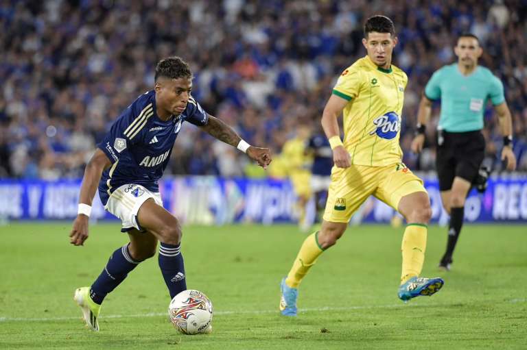 Emerson Rodríguez (Millonarios) ante la marca de Leonardo Flores (Bucaramanga) en El Campín.