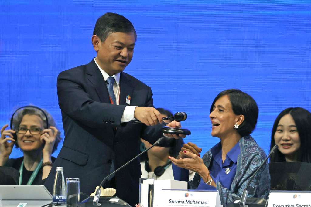 AME9389. CALI (COLOMBIA), 21/10/2024.- El ministro de Ecología y Medio Ambiente de China, Huang Runqiu (i) entrega el mazo de la presidencia de la Cumbre de Naciones Unidas de Biodiversidad, COP16, a la ministra de Ambiente y Desarrollo Sostenible de Colombia, Susana Muhamad, durante el inicio de la primera plenaria, este lunes, en Cali (Colombia). Muhamad asumió en Cali la presidencia de la Conferencia de las Naciones Unidas sobre Biodiversidad (COP16) en la primera sesión plenaria de esta reunión en la que alertó que el tiempo corre en contra de la naturaleza. EFE/ Mauricio Dueñas Castañeda