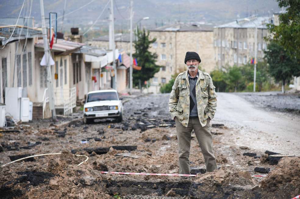 Un hombre en medio de un territorio afectado por los combates en Nagorno Karabaj.