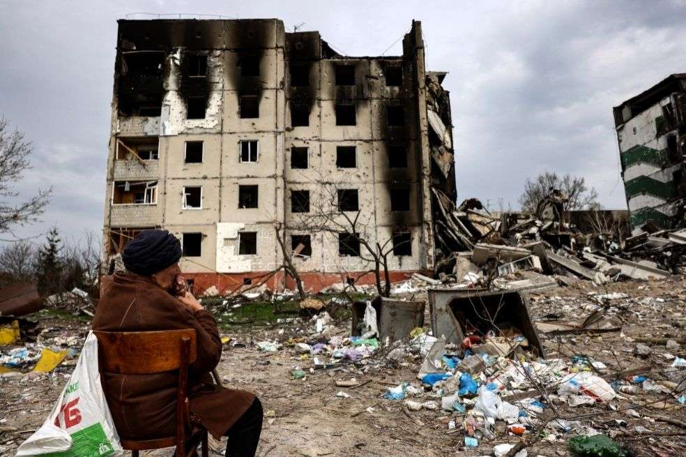 Un hombre ucraniano espera el cuerpo de su hijo frente a un edificio derrumbado en la ciudad de Borodianka, al noroeste de Kiev.