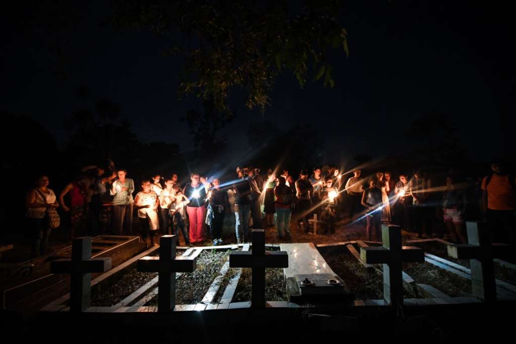 un grupo de personas se encuentran en un evento simbólico con velas.