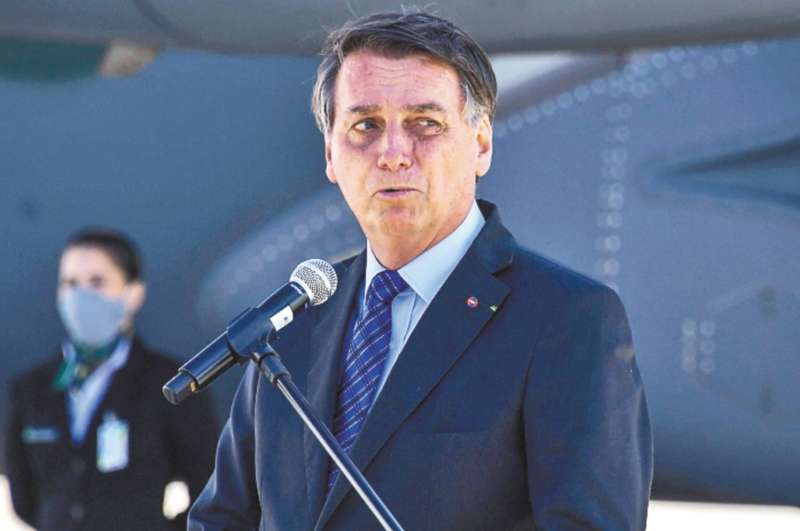 Desde que comenzó la pandemia Bolsonaro desafió casi a diario al virus circulando por las calles en plena cuarentena, asistiendo a actos públicos sin utilizar mascarilla y abrazando y besando a partidarios sin cuidado alguno. / AFP / Nelson ALMEIDA