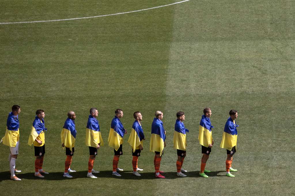 Kyiv (Ukraine), 23/08/2022.- Players of Shakhtar Donetsk draped in Ukrainian flags stand before the opening soccer match of the new season of Ukrainian Premier League between Shakhtar Donetsk and Metalist 1925 Kharkiv at the empty Olimpiyskiy stadium, in Kyiv, Ukraine, 23 August 2022. Ukrainian football Premier League began its new season on 23 August with out fans amid fears of bombs annd missiles alerts, a day before six months of the Russian invasion are marked. Russian troops on 24 February 2022 entered Ukrainian territory, starting a conflict that provoked destruction and a humanitarian crisis. (Abierto, Rusia, Ucrania) EFE/EPA/ROMAN PILIPEY