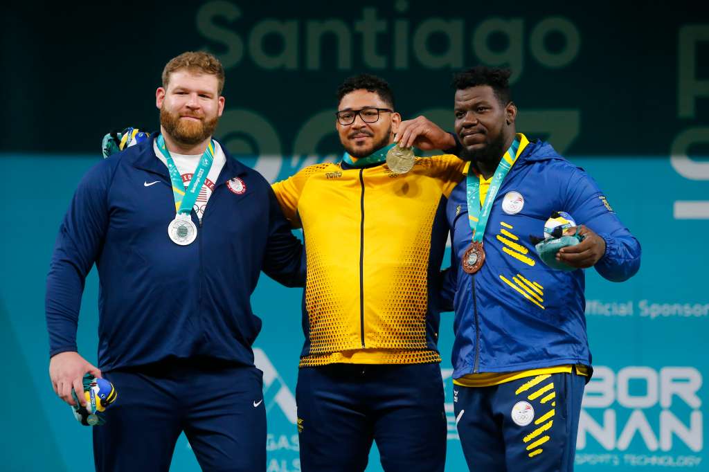 EVE3322. SANTIAGO (CHILE), 24/10/2023.- Rafael Cerro (c) de Colombia, medalla de oro, Keiser Witte (i) de los Estados Unidos, plata, y Dixon Arroyo de Ecuador, bronce, posan en el podio de levantamiento de pesas +102 kg masculino hoy, durante los Juegos Panamericanos 2023 en Santiago (Chile). EFE/ Esteban Garay